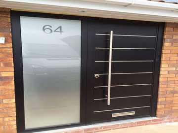 Ormskirk Liverpool. Installtion of our new Aluminium Contempory door range . 44mm and 100mm thick . Sandblst glass to side panel. Double glazed . Argon Gas filled . 1200mm Alpro handles . 9005 Ral.